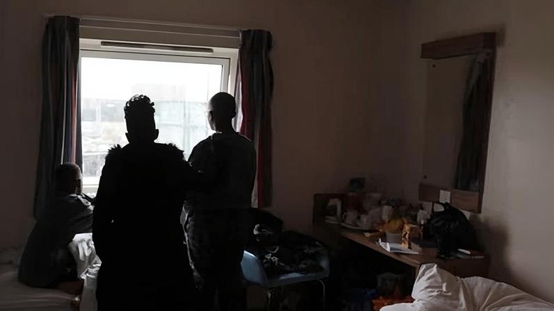 A family staying in temporary accommodation in a Travelodge hotel room.