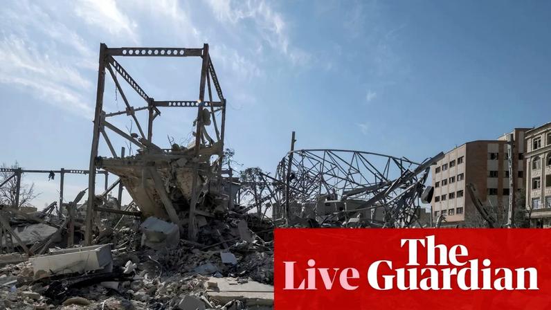 An Iranian woman walks past a diplomatic police station that is completely destroyed during the US-Israeli military campaign in Tehran. Follow the latest news and live updates from the US-Israel war on Iran.