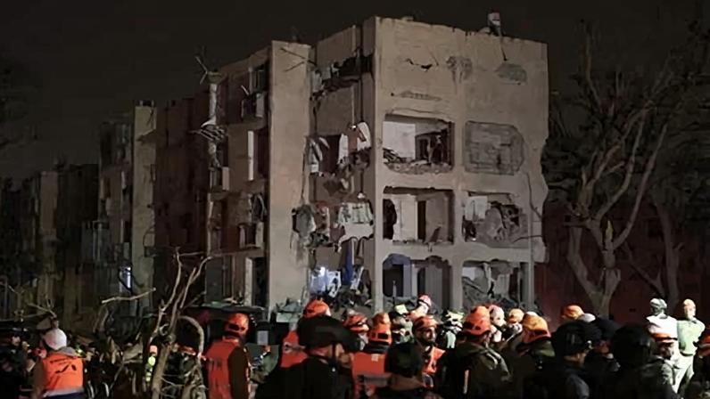 First responders inspect the site of an Iranian missile strike in Arad, Israel, on March 22, 2026.