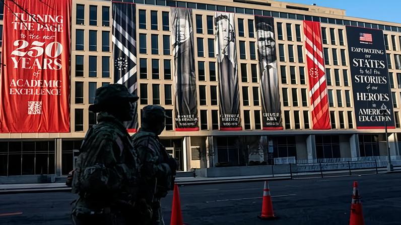Members of the US national guard walk past banners featuring Booker T Washington, Catherine Beecher and Charlie Kirk hanging at the US Department of Education in Washington DC on 1 March 2026.