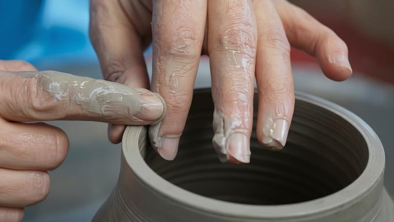 A Denby pottery worker adds a spout to a jug.