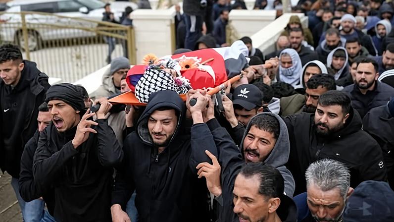 Mourners carry the body of Palestinian American Nasrallah Abu Siyam, 19, during his funeral in the West Bank village of Mukhmas on 19 February 2026.