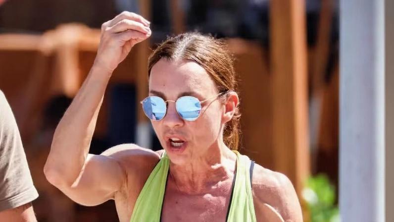 Carla Marins exibe braços musculosos em passeio na praia