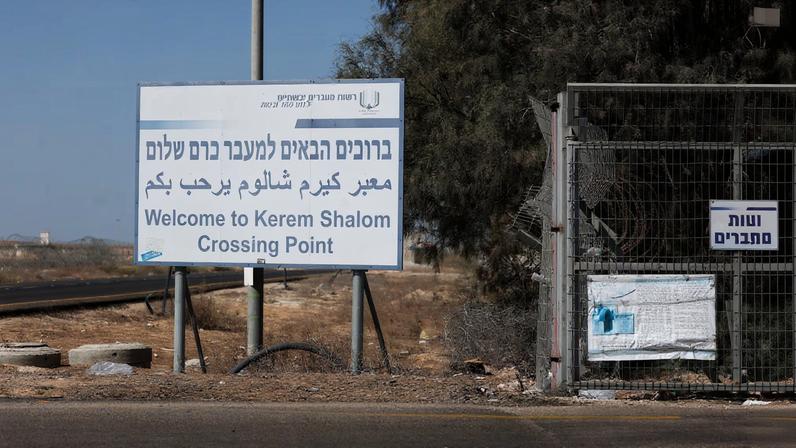 A view shows a sign as trucks carrying aid (not pictured) wait at the Israeli side of the Kerem Shalom border crossing to southern Gaza in southern Israel, October 20, 2025. REUTERS/Hannah McKay/File Photo