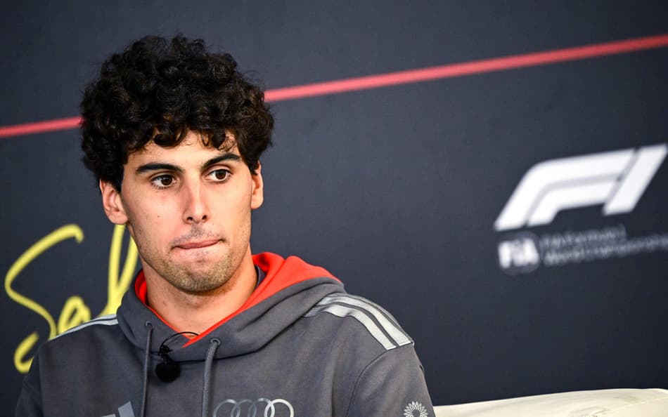 O brasileiro da Audi Gabriel Bortoleto caminha pelo paddock no primeiro dia do segundo teste de pré-temporada da Fórmula 1 no Circuito Internacional do Bahrein, em Sakhir, em 18 de fevereiro de 2026 (Foto: Giuseppe cacace/afp)
