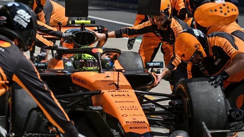 Mecânicos trabalham no carro de Lando Norris durante treino para o GP da China de Fórmula 1, em 13 de março de 2026. (Foto: Hector Retamal/AFP)
