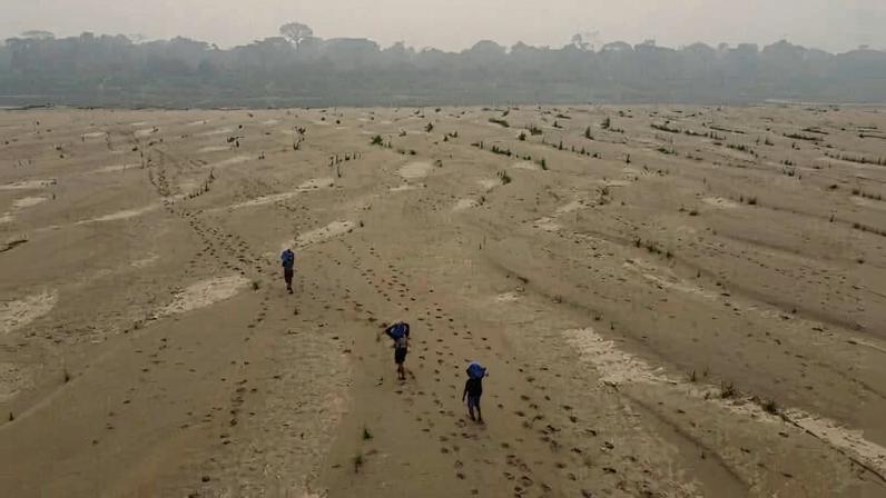 Residents transport drinking water along the dry Madeira River, a tributary of the Amazon River, during the dry season, in 2024. Image by AP Photo/Edmar Barros.