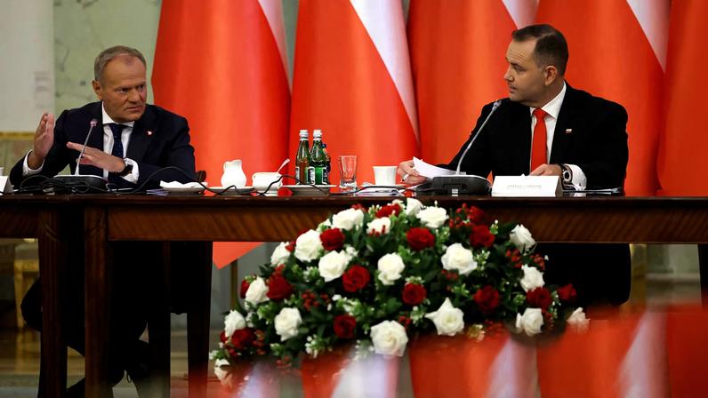 Poland's Prime Minister Donald Tusk speaks to President Karol Nawrocki during a Cabinet Council meeting led by the president, at the Presidential Palace in Warsaw, Poland, August 27, 2025.