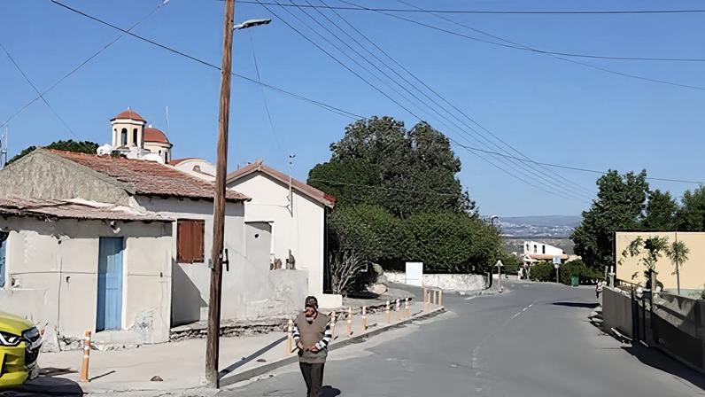 Un vecino de Akrotiri camina por una calle del pueblo desierta, este martes.