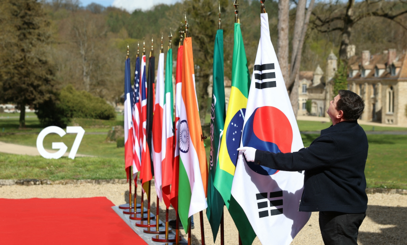 A staff member hangs South Korea’s national flag before the arrival of officials for a G-7 foreign ministers’ meeting.