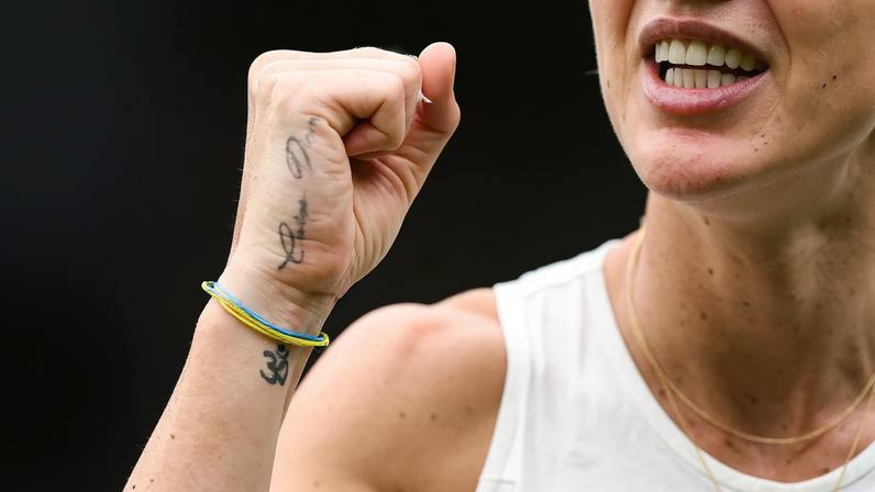 A tattoo reading "Carpe Diem" and a bracelet with the colors of the Ukrainian flag are pictured on the hand of Ukraine's Elina Svitolina.