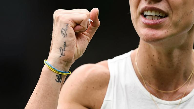 A tattoo reading "Carpe Diem" and a bracelet with the colors of the Ukrainian flag are pictured on the hand of Ukraine's Elina Svitolina.
