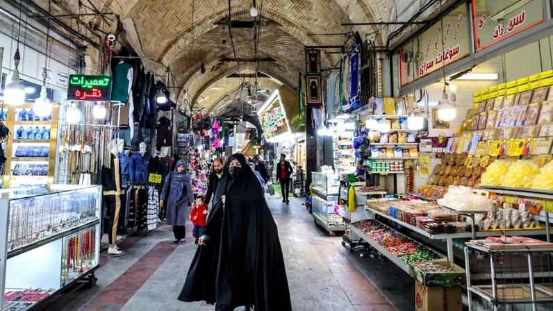 A woman walks at the old bazaar in the city of Shahr-e Ray, south of Tehran, on January 8, 2024.