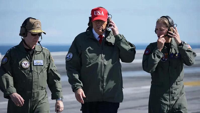 President Donald Trump observes naval flight demonstrations on the deck of the USS George H.W. Bush aircraft carrier on October 5, 2025 off the eastern coast of the United States.