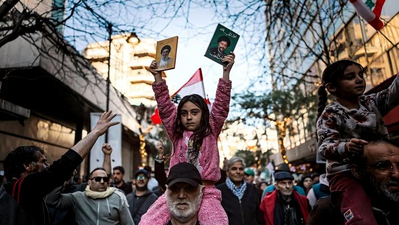A girl holds a picture of slain Hezbollah leader Hassan Nasrallah in Beirut on March 8, during a protest against the ongoing Israel-Hezbollah hostilities.