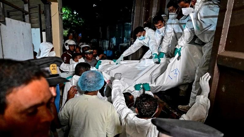 Profissionais de saúde carregam os corpos de marinheiros iranianos que morreram em um ataque americano contra a fragata IRIS Dena, na costa sul do Sri Lanka, em 4 de março de 2026.