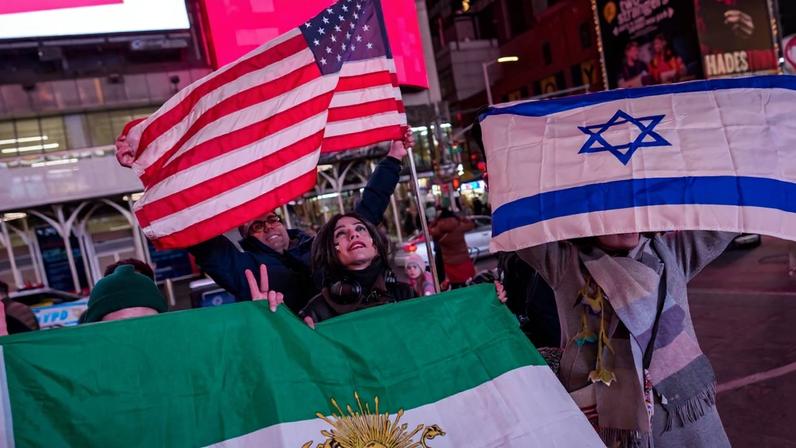 People hold a pre-revolution Iranian flag, a U.S. flag, and an Israeli flag during a “Freedom for Iran” rally in Times Square in New York on March 2.