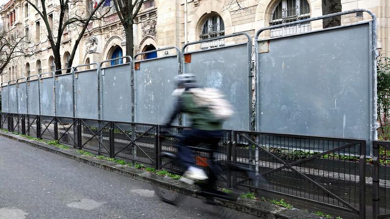 A man rides his bicycle past newly installed electoral campaign panel boards ahead of the upcoming mayoral elections in Paris, France, February 24, 2026. REUTERS/Abdul Saboor/File Photo