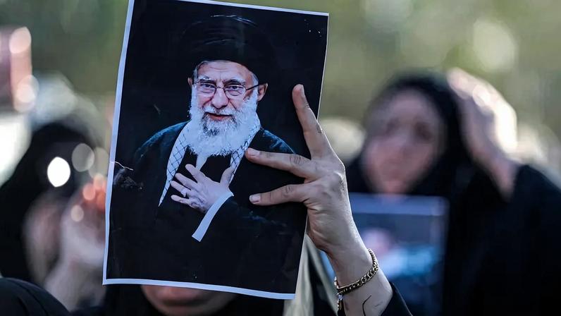 A woman holds up an image of Iran's supreme leader, Ayatollah Ali Khamenei, during a symbolic funeral in Baghdad on March 1.