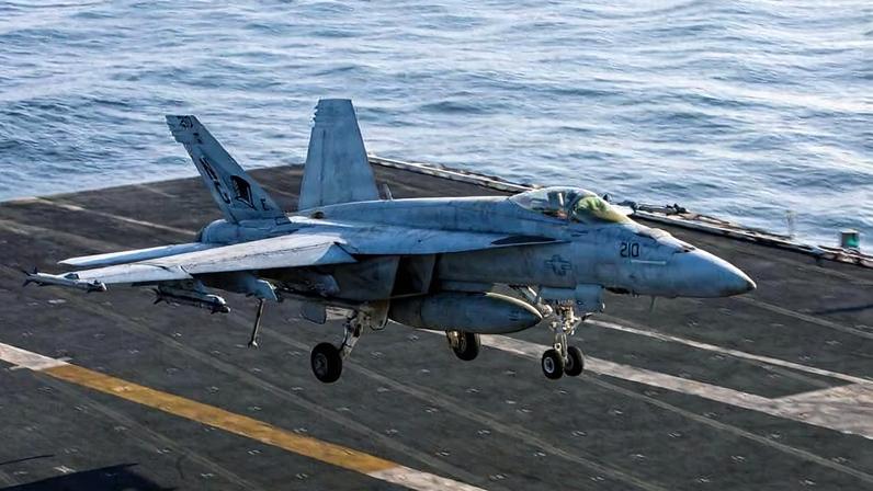An F/A-18E Super Hornet participating in U.S. military operations against Iran prepares to land on the flight deck of the USS Abraham Lincoln aircraft carrier.