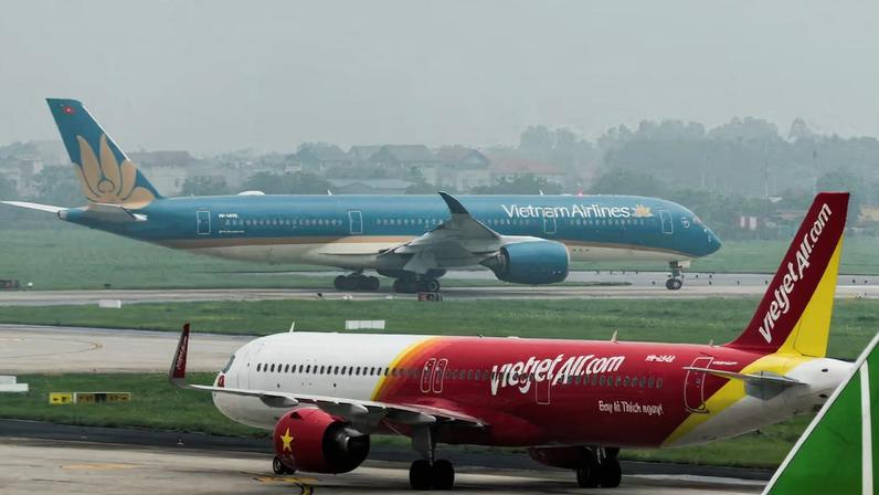 An airplane of VietJet Airline taxis in front of the national flag carrier Vietnam Airlines airplane, at Noi Bai International Airport, in Hanoi