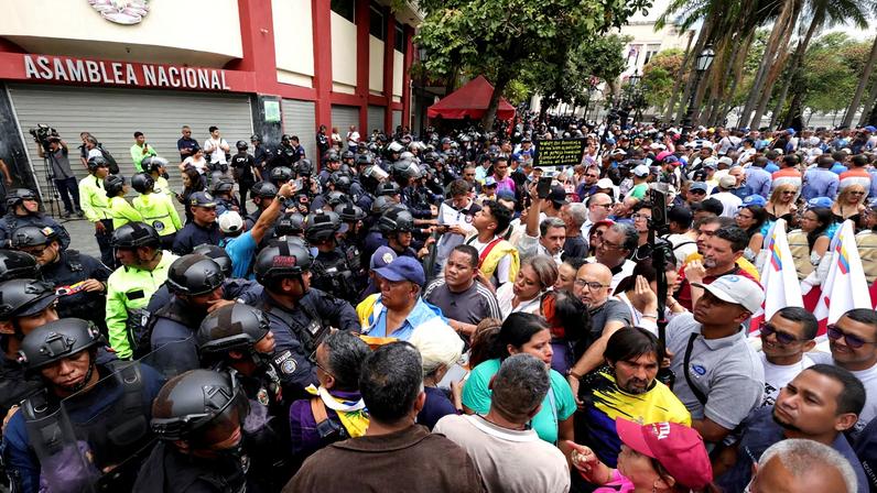 Protesters rally outside the National Assembly demanding higher wages, improved pensions, restored labor rights and the release of detainees in Caracas, Venezuela, March 12, 2026. REUTERS/Gaby Oraa