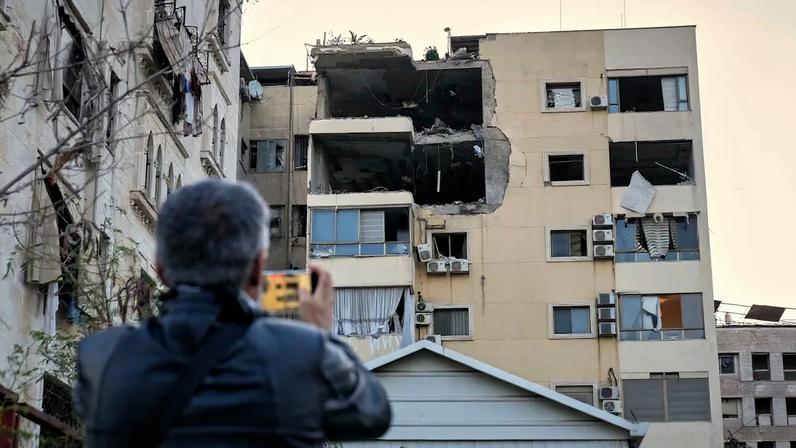 Un hombre toma fotografías de los daños en un edificio de apartamentos tras un ataque aéreo israelí, al sur de Beirut, Líbano, este lunes.