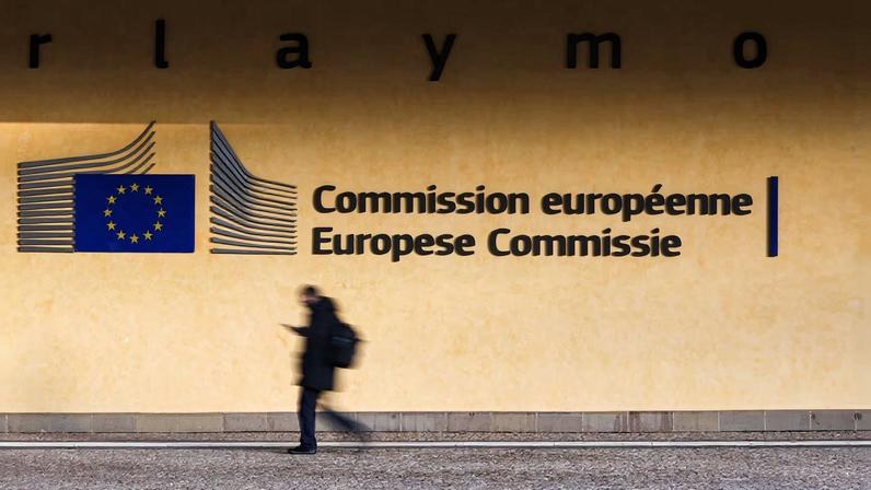 A person walks past the entrance of the European Commission headquarters in Brussels