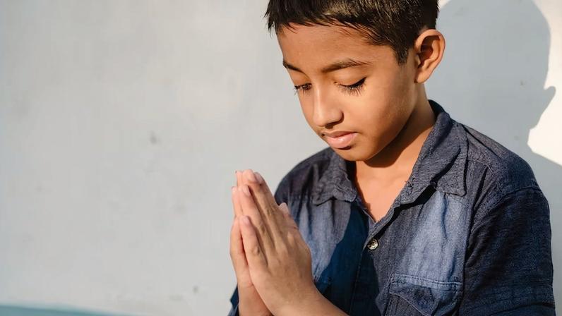 Robin orando, expressando a fé e perseverança de crianças perseguidas em Bangladesh