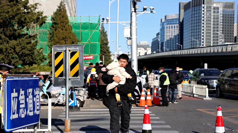 A man carries a child outside a children's hospital in Beijing