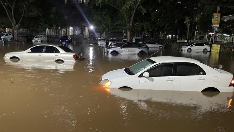 Vehicles on March 6 partially submerged in at a flooded parking lot in Nairobi, Kenya, after days of heavy rainfall.