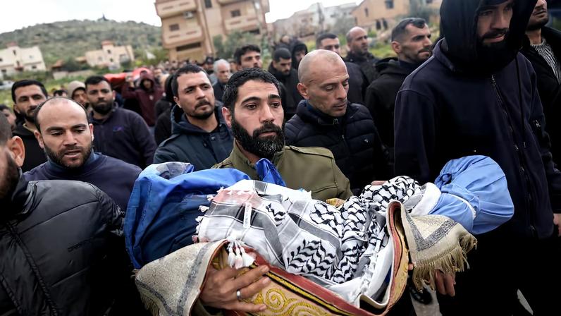Un hombre lleva el cuerpo de Mohamed Bani Odeh, de cinco años, en el funeral por los cuatro miembros de la familia a los que soldados israelíes han matado a tiros este domingo en Tammun, en el territorio palestino ocupado de Cisjordania.
