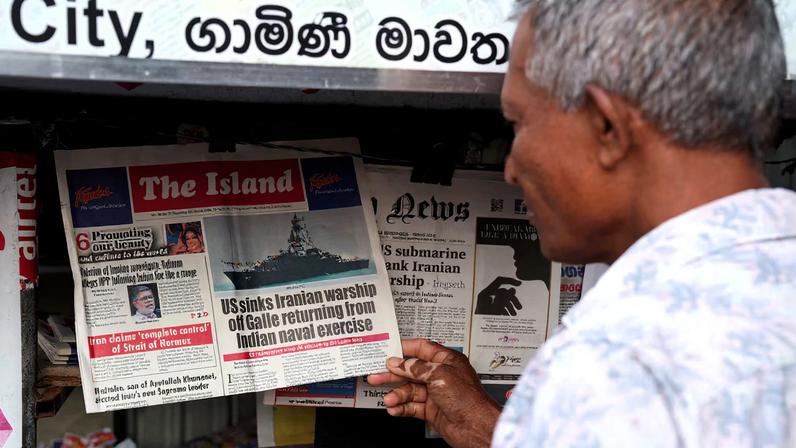 A man checks the local newspaper, follwoing a submarine attack on the Iranian military ship, IRIS Dena, off the coast of Sri Lanka