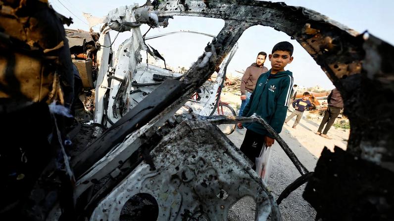 Palestinians inspect the site of an Israeli airstrike targeting a police vehicle in the central Gaza Strip, March 15, 2026. REUTERS/Mahmoud Issa