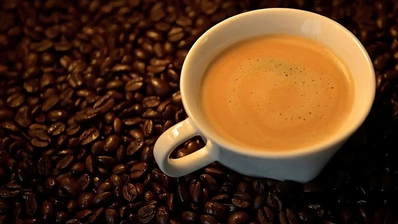 Xícara de café no meio de grãos torrados