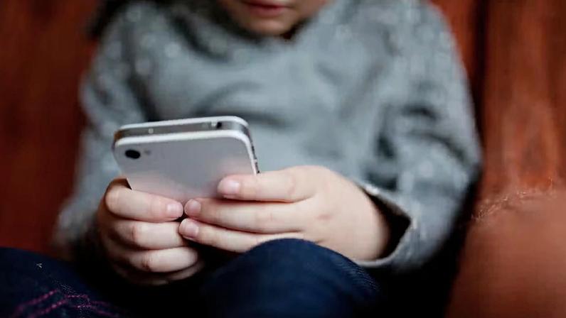 Criança no celular — Foto: Canva