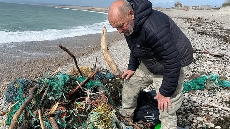 Voluntários limpam praia de lixo de pesca após tempestade