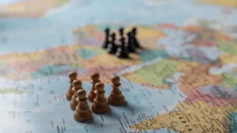 Movimentos estratégicos em um mapa mundi com peças de xadrez simbolizando influência global e dinâmicas de poder.
