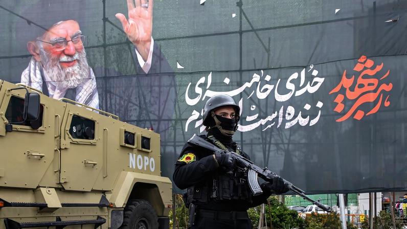 A police officer stands near a poster featuring the late Supreme Leader Ali Khamenei on March 28 in Tehran, Iran.