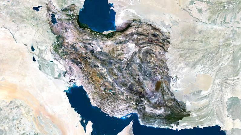 A satellite view of Iran shows water to the south and north and mountainous terrain.