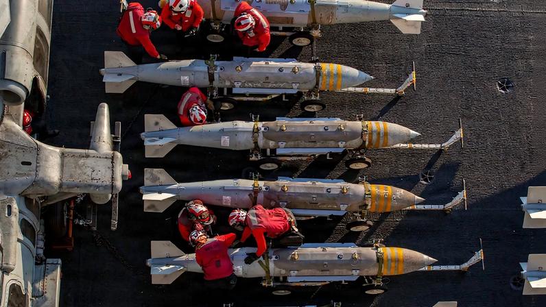 U.S. sailors prepare to stage ordnance on the USS Abraham Lincoln aircraft carrier during Operation Epic Fury while at sea.
