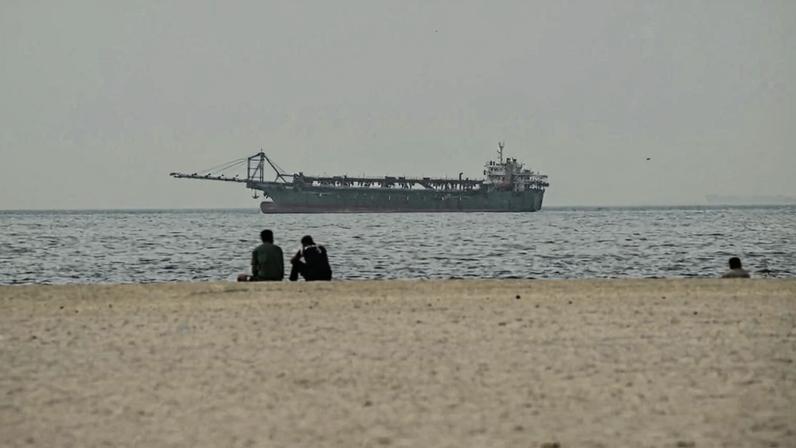 People sit on Ajman Beach in Dubai on March 2.