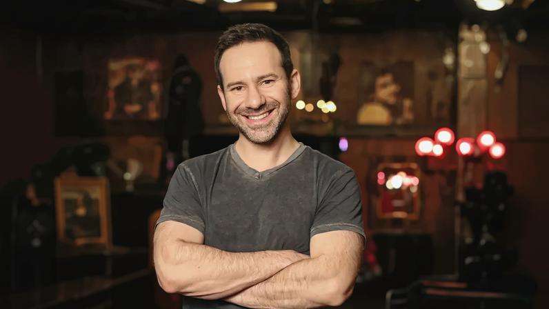 Leonid Radvinsky, owner of OnlyFans, smiling with arms crossed.