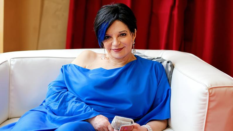 Liza Minnelli in a blue off-the-shoulder outfit.