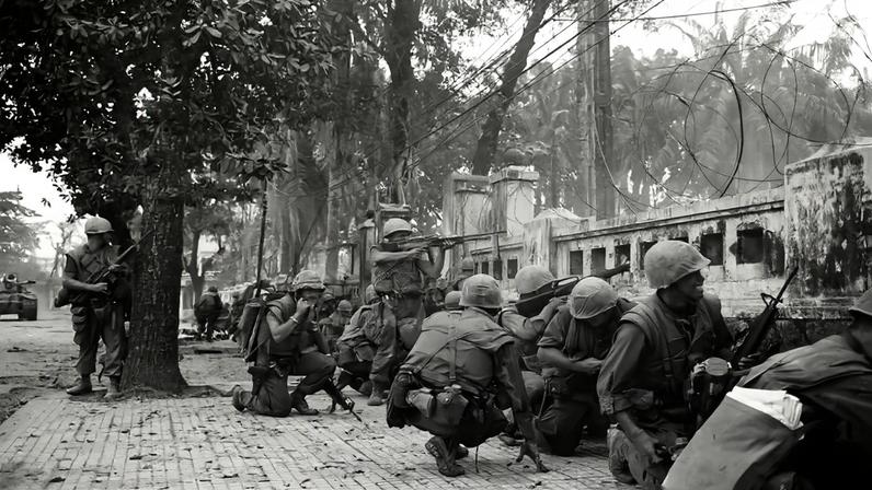 U.S. Marines hide behind a wall in Hue, South Vietnam in February 1968.