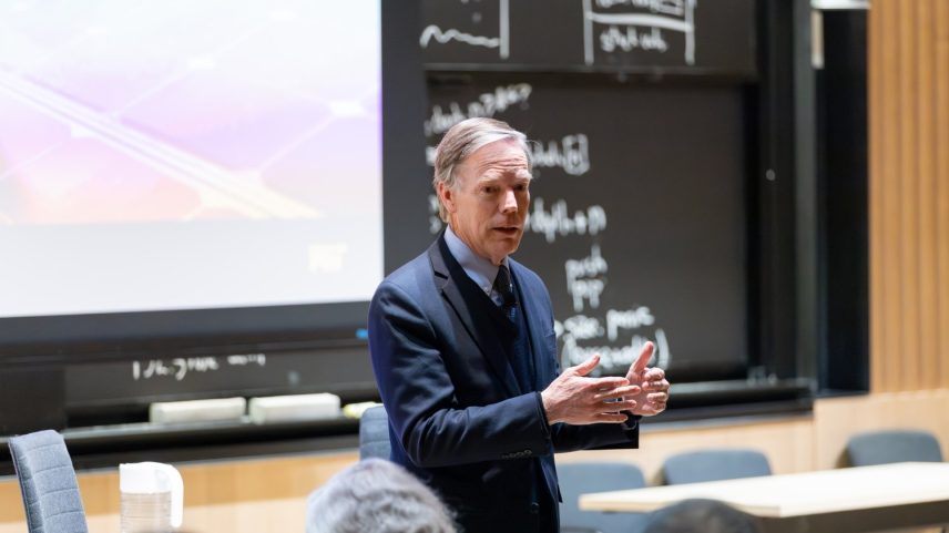 Nicholas Burns stands in front of audience, speaking at seminar