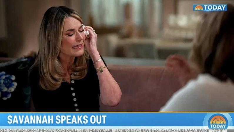 Savannah Guthrie crying and wiping a tear from her eye.