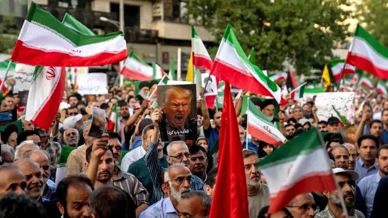 Iranian protesters chant slogans and one holds a poster with a vampire-like illustration of U.S. President Donald Trump in Tehran, Iran, on June 22, 2025.