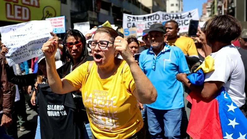 Workers participate with slogans and signs during a protest against salary and work conditions in Caracas, Venezuela, on March 23.