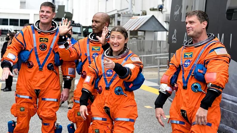 Da direita para a esquerda, os astronautas da NASA Reid Wiseman, comandante; Christina Koch, especialista de missão; Victor Glover, piloto; e o astronauta da CSA (Agência Espacial Canadense) Jeremy Hansen, especialista de missão, acenam para familiares e amigos enquanto se preparam para deixar o Edifício de Operações e Verificação Neil A. Armstrong e embarcar em sua espaçonave Orion, a bordo do foguete Space Launch System (SLS) da NASA, no Complexo de Lançamento 39B